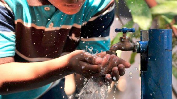 Una persona recibe agua de una pileta.