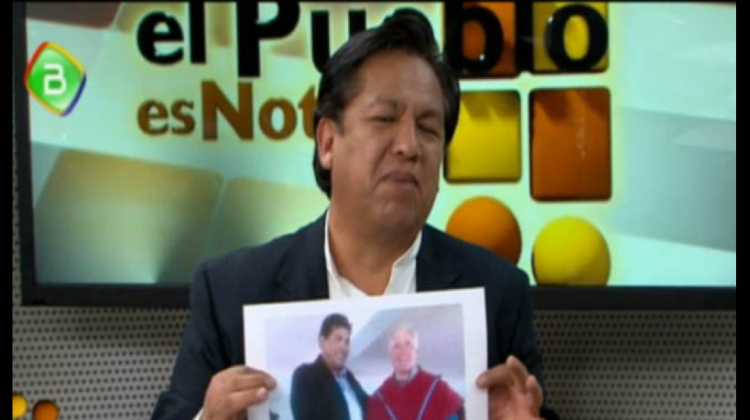 El ministro de la Presidencia, René Martínez muestra una fotografía de Brennan y el acalde de Ancoraimes. Foto: Captura pantalla BTV.