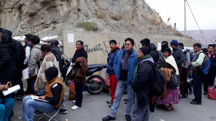 Jóvenes y padres de familia hacen una fila para inscribirse a un centro de reclutamiento.