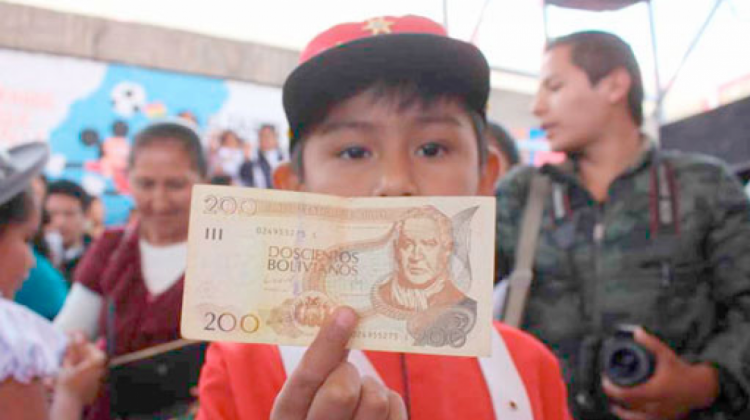 Un escolar muestra un billete de Bs 200 como parte del bono Juancito Pinto.   Foto: ABI