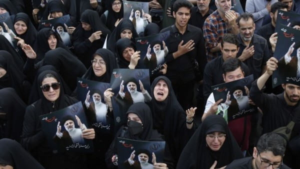 Personas lloran la muerte de Ebrahim Raisi, presidente de Irán.