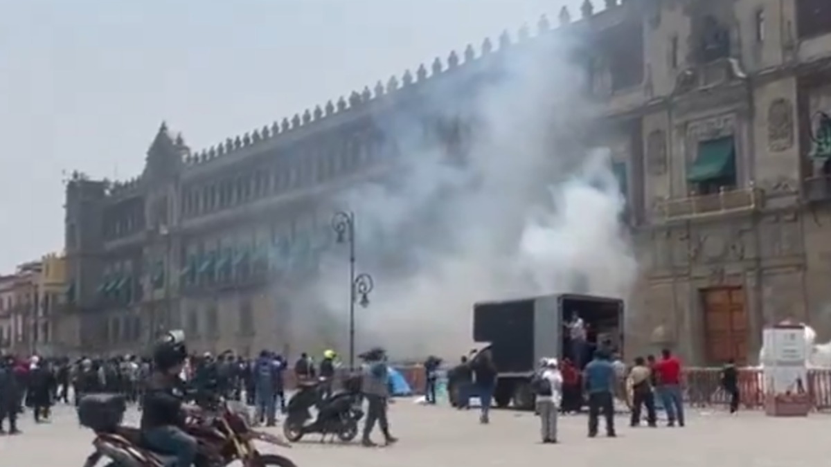 Estudiantes de la escuela normal de Ayotzinapa lanzan artefactos explosivos contra la fachada de Palacio Nacional de Ciudad de México.