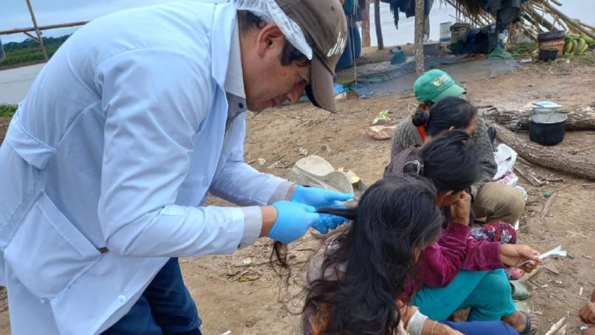 Médico revisa el cabello de indígenas de Bolivia.