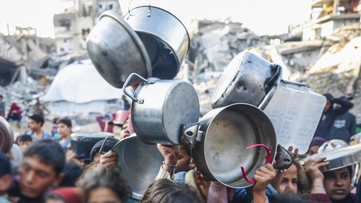 Personas esperan alimento en la Franja de Gaza.