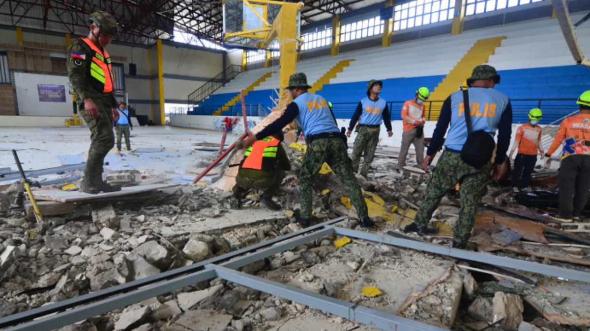 Rescatistas buscan entre los escombros tras el sismo en Filipinas.