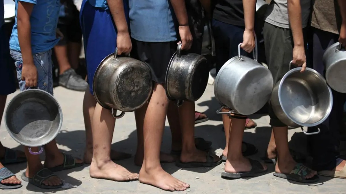 Personas hacen fila para recibir alimentos en campamento de la Franja de Gaza.