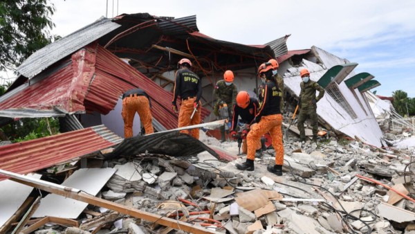 Equipos de rescate buscan en medio de los escombros tras el sismo de magnitud 7,8 en el sur de Filipinas.