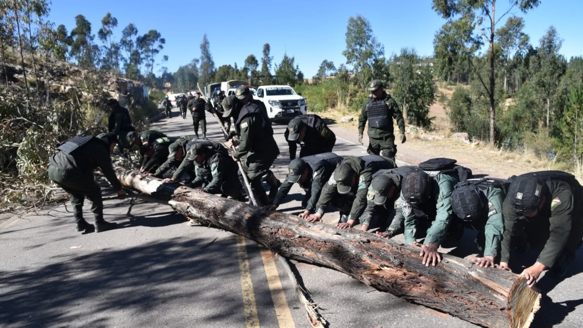 La Policía retira un enorme tronco que sirvió a los bloqueadores cortar el paso.  Foto: Policía